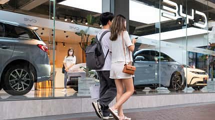 byd,chinese,pedestrians,brand,automaker Pedestrians walk past the Chinese automaker BYD official